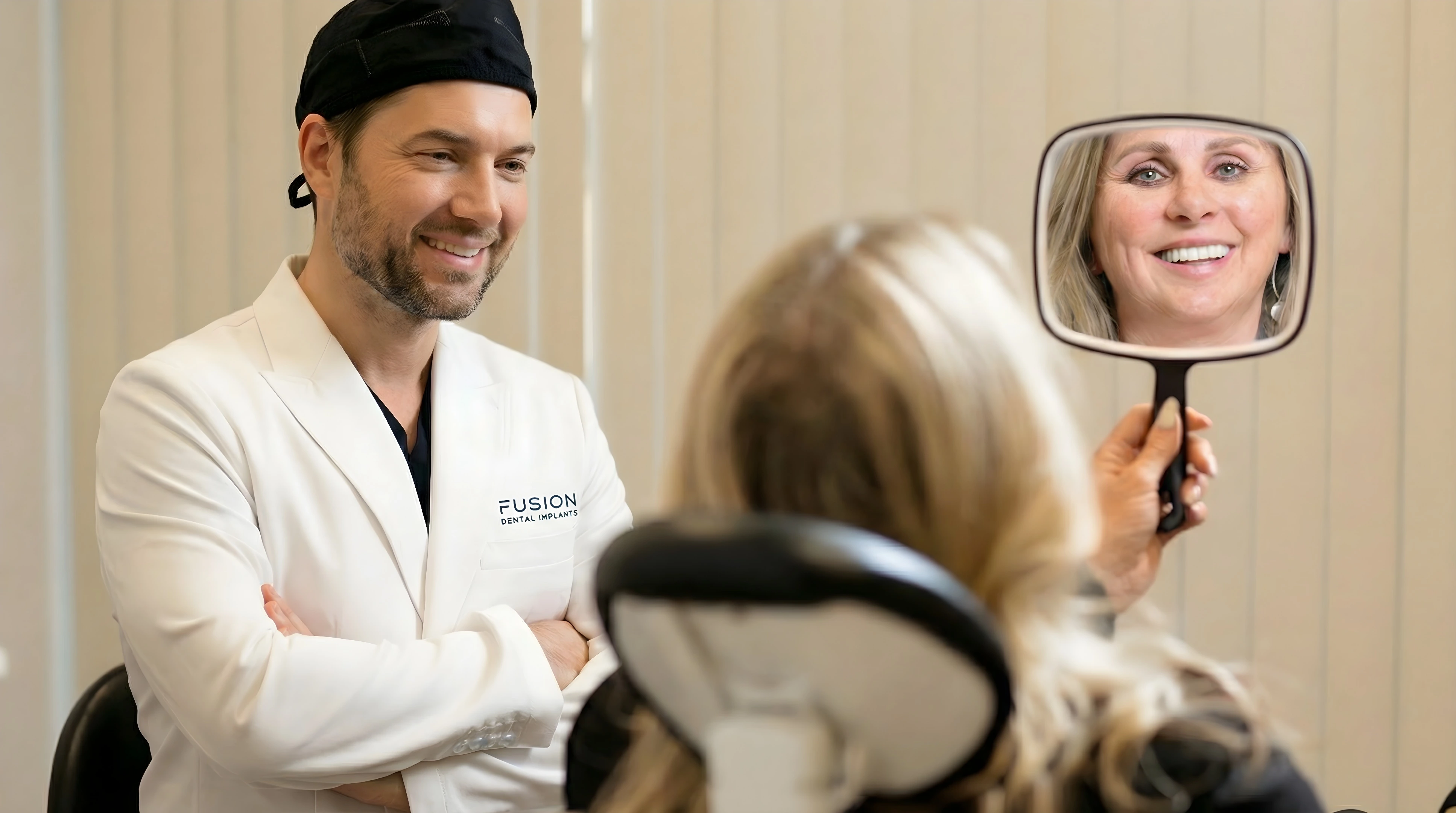 Dr. Antipov with patient admiring her new smile in mirror at Fusion Dental Implants