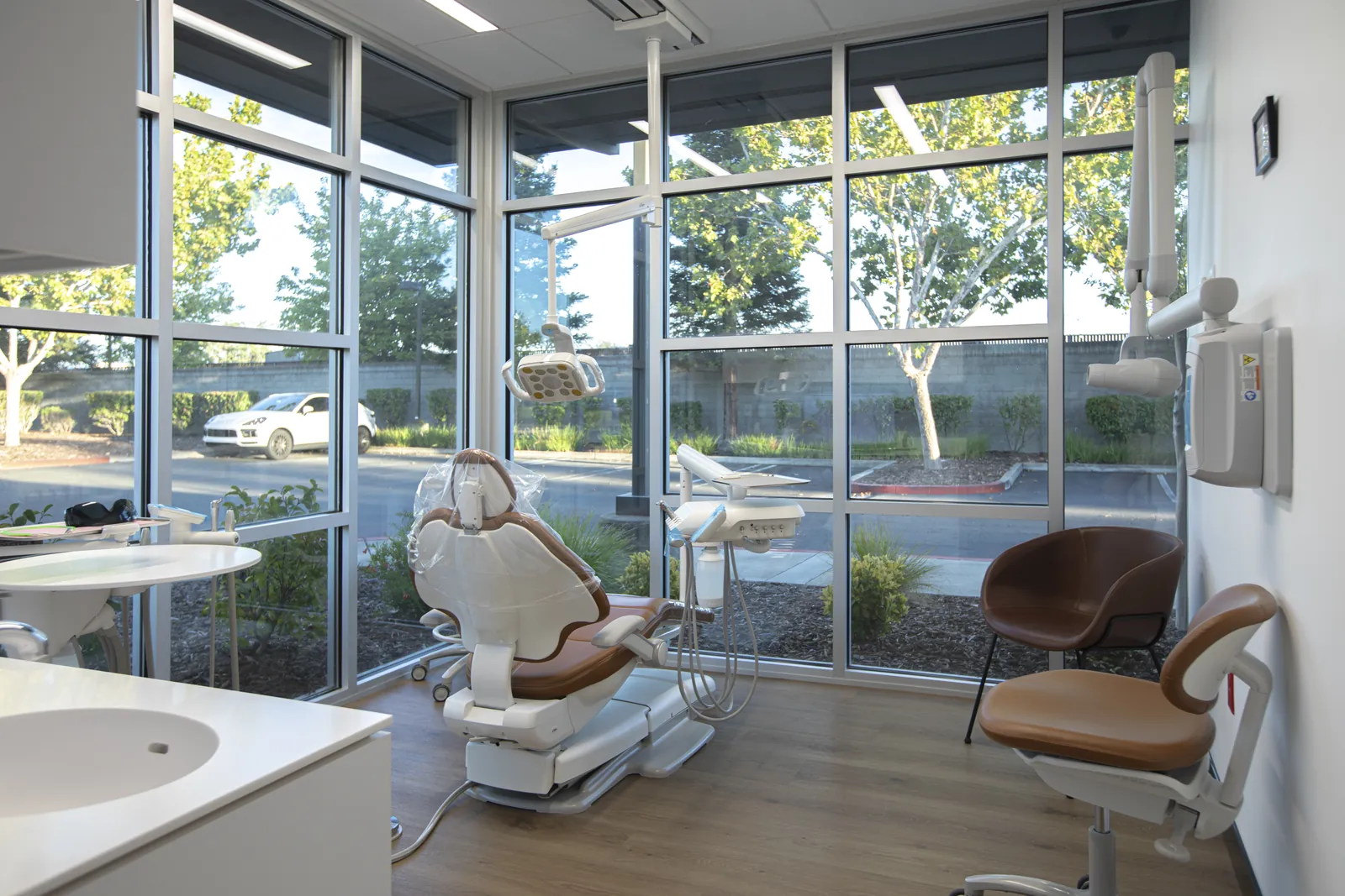 Dental treatment room with a patient chair beside the windows